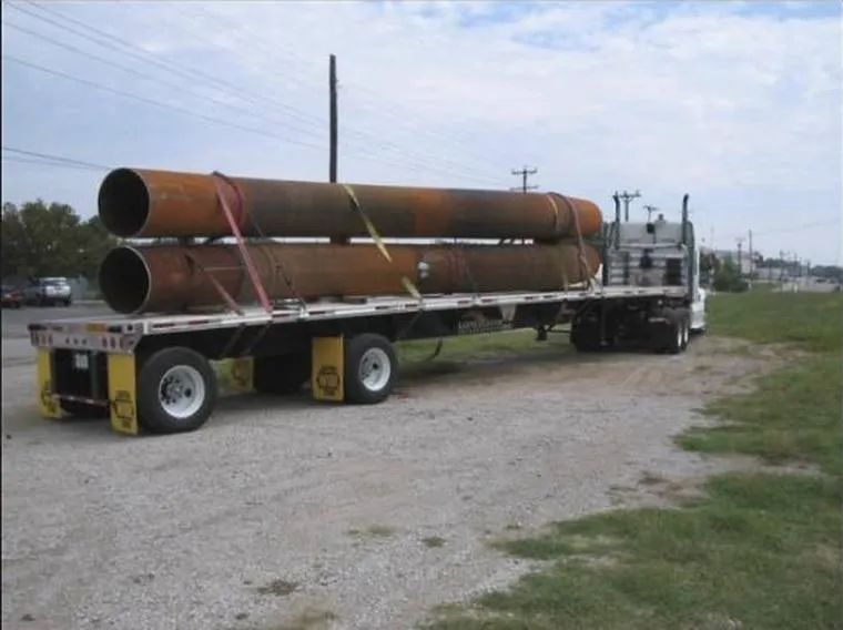 Large-diameter pipe and bends loaded on a flatbed trailer for shipping