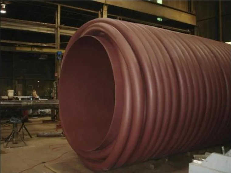 A large helical coil resting on the shop floor after winding