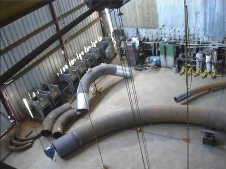 Large-diameter bends and fittings staged on the American Pipe Bending shop floor