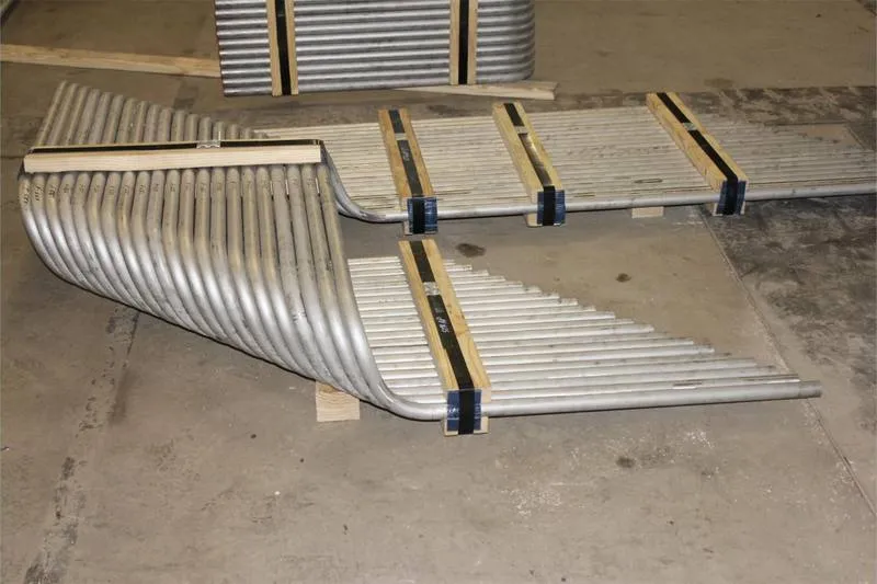 A cold bent serpentine tube panel laid out on timber blocks in the yard